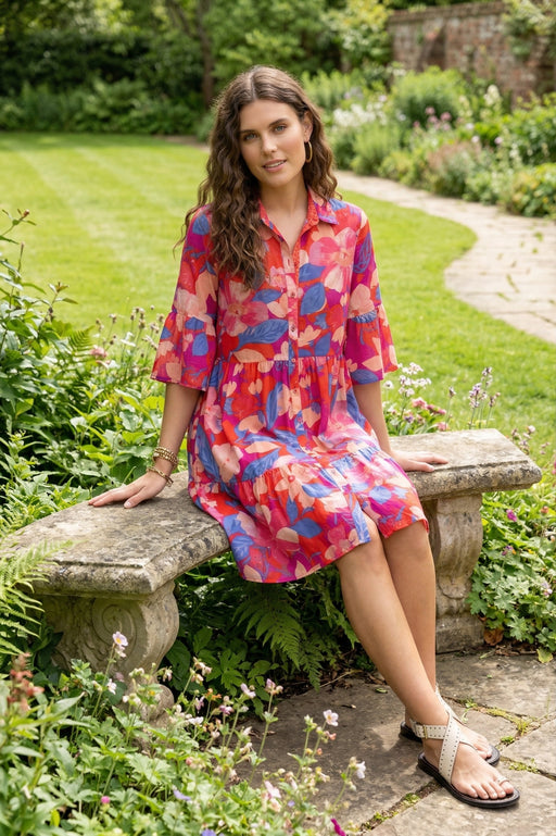 Woman wearing a colorful floral button front dress with ruffle sleeves from Johnny Was