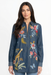 Woman wearing a denim shirt tunic with colorful floral and animal embroidery from Johnny Was
