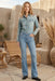 Woman wearing a blue denim shirt with geometric embroidery and chest pockets from Johnny Was