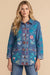 Woman wearing a blue denim jacket with colorful floral and geometric embroideries from Johnny Was