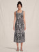 Woman wearing a black and white tropical patterned midi dress with square neck and  wide tank straps from Johnny Was