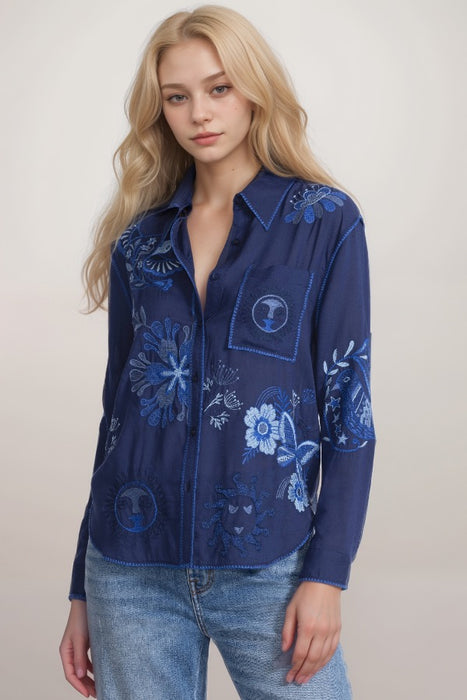Woman wearing a blue shirt with blue embroidery and chest pocket