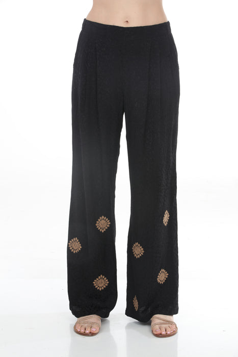 Woman wearing a black wide leg pleated pants with embroidery from Johnny Was