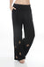 Woman wearing a black wide leg pleated pants with embroidery from Johnny Was