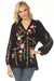 Woman wearing a black floral embroidered silk shirt with raglan puff sleeves from Johnny Was
