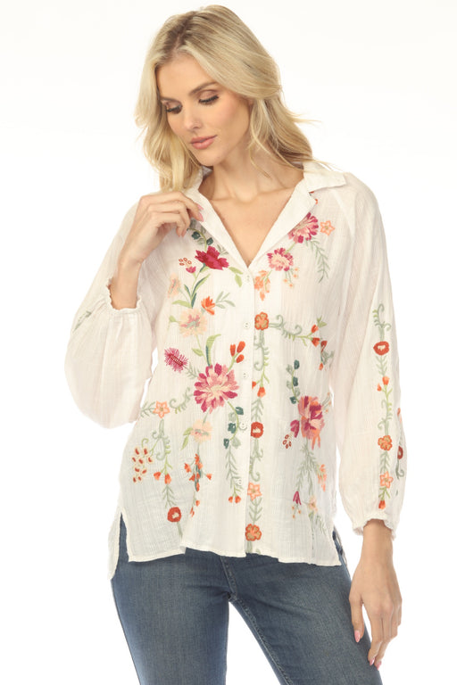 Woman wearing a white plaid shirt with colorful floral embroideries and raglan sleeves from Johnny Was