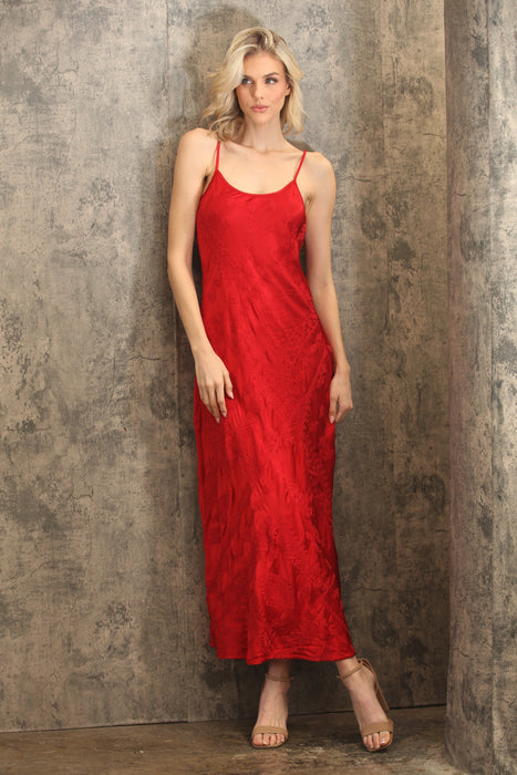 Woman wearing a red embroidered maxi slip dress with scoop neck and adjustable spaghetti straps from Johnny Was