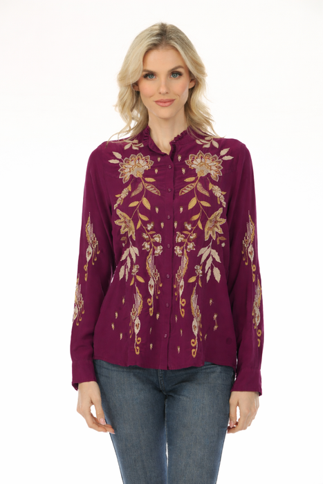 Woman wearing a plum-colored long sleeve blouse with gold floral embroidery from Johnny Was