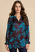 Woman wearing a two-tone floral printed tunic top with v-neck and long sleeves from Johnny Was