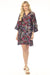 Woman wearing a silk kimono sleeve shift dress with colorful floral print and tie front neck from Johnny Was