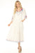 Woman wearing a white embroidered maxi dress with tasseled split v-neck and tiered skirt from Johnny Was
