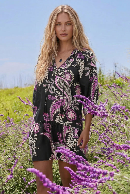 Woman wearing a black tiered dress with floral paisley print and 3/4 sleeves from Johnny Was