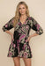 Woman wearing a black tiered dress with floral paisley print and 3/4 sleeves from Johnny Was