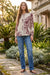 Woman wearing a beige long sleeves top with contrasting florals over plaid pattern from Johnny Was