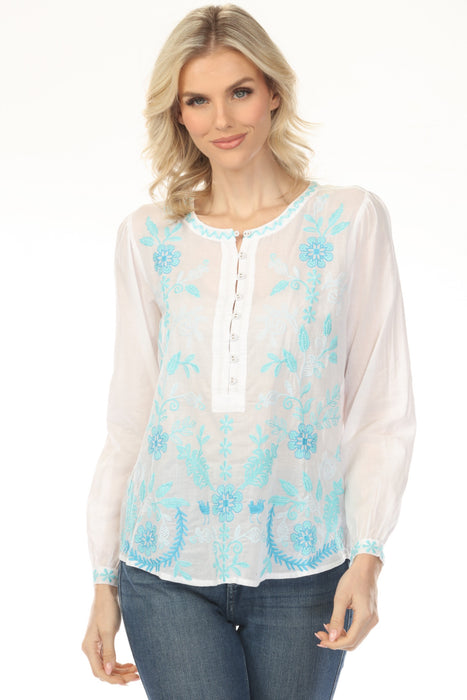 Woman wearing a white henley long sleeve blouse with blue floral embroidery from Johnny Was