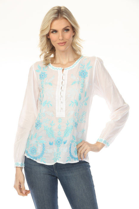 Woman wearing a white henley long sleeve blouse with blue floral embroidery from Johnny Was