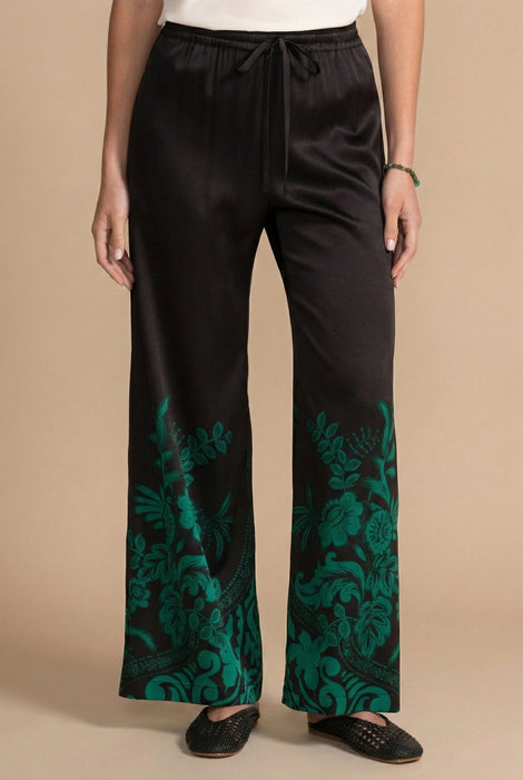 Woman wearing a black wide leg pant with green floral print from Johnny Was