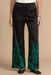 Woman wearing a black wide leg pant with green floral print from Johnny Was