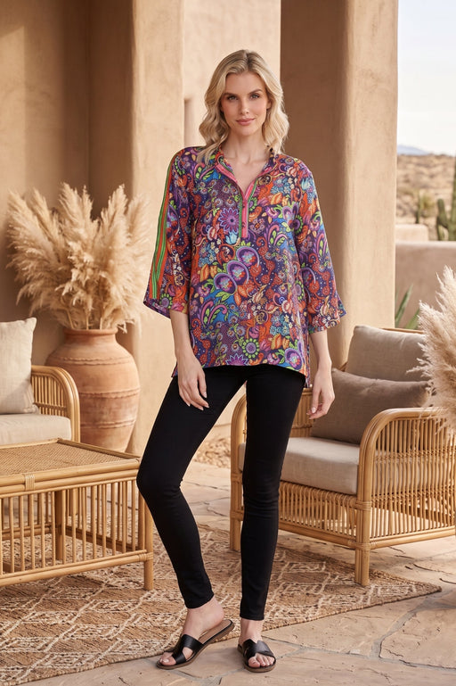 Woman wearing a colorful floral printed 3/4 sleeves tunic top with half button closure from Johnny Was.