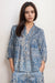 Woman wearing a blue denim patterned floral silk blouse with pintuck detail and ruffle on the 3/4 sleeves