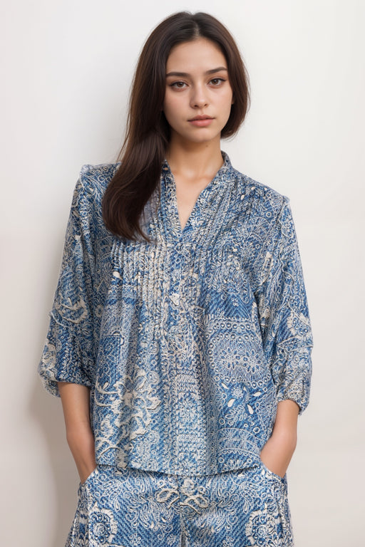 Woman wearing a blue denim patterned floral silk blouse with pintuck detail and ruffle on the 3/4 sleeves