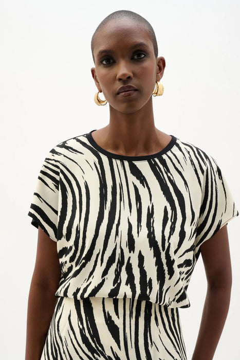 Woman wearing Joseph Ribkoff animal print silky knit back top for office outfit