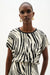 Woman wearing Joseph Ribkoff animal print silky knit back top for office outfit