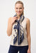 Woman wearing a beige and blue polka dot scarf with fringe edges from Joseph Ribkoff