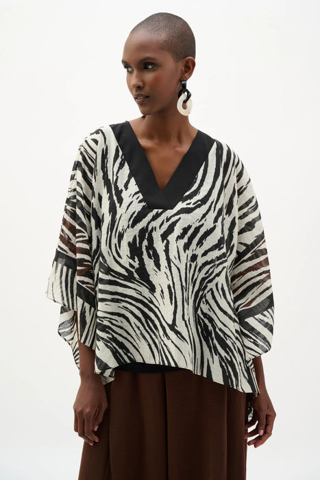 Woman wearing Joseph Ribkoff animal print poncho top for resort vacation outfit