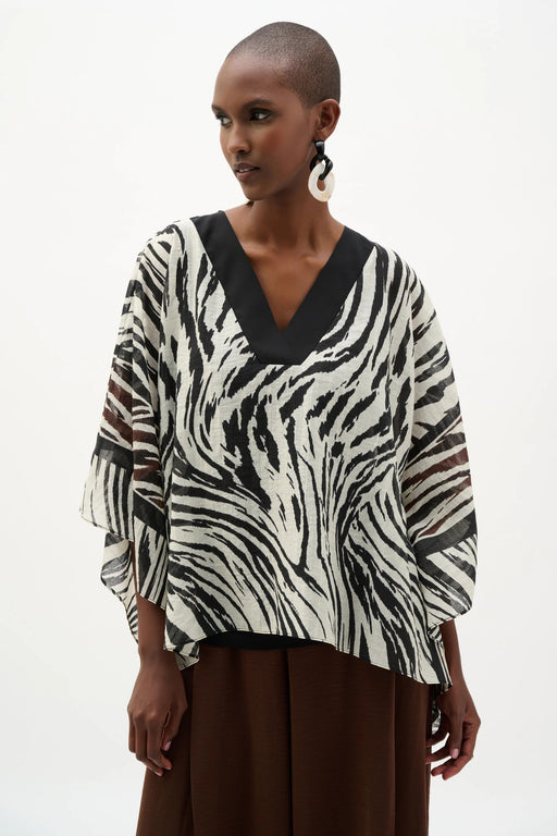 Woman wearing Joseph Ribkoff animal print poncho top for resort vacation outfit