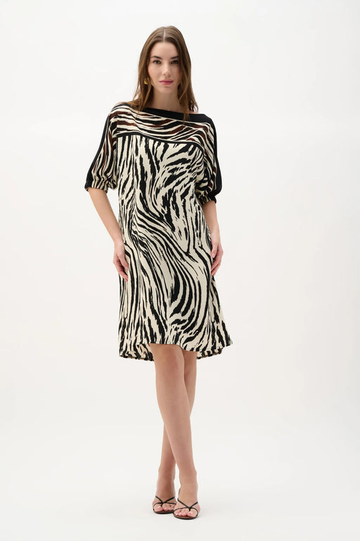 Woman wearing Joseph Ribkoff animal print straight dress featuring zebra-inspired black and beige pattern, knee-length cut, relaxed sleeves, and a modern flattering fit.