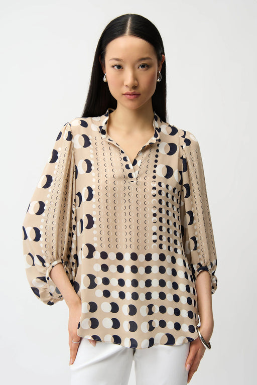 Woman wearing a dot patterned tunic top with split v-neck and 3/4 puff sleeves from Joseph Ribkoff