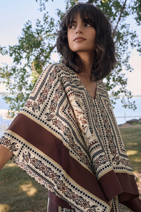 Woman wearing Joseph Ribkoff georgette printed poncho top styled for resort wear, vacation outfits, summer outings, and bohemian chic looks.
