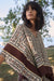 Woman wearing Joseph Ribkoff georgette printed poncho top styled for resort wear, vacation outfits, summer outings, and bohemian chic looks.