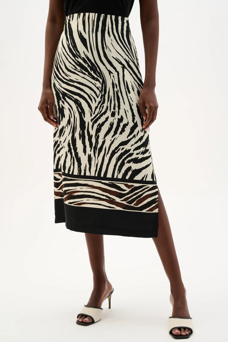 Woman wearing Joseph Ribkoff beige multi woven animal print straight skirt, featuring a sleek midi length, bold pattern, structured fit, and a subtle side slit for movement.