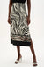 Woman wearing Joseph Ribkoff beige multi woven animal print straight skirt, featuring a sleek midi length, bold pattern, structured fit, and a subtle side slit for movement.