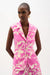 Woman wearing a beige and pink floral print sleeveless vest with a tailored fit and button-front design, styled for a chic and modern look.