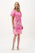 Woman wearing a beige and pink floral print trapeze dress with short puff sleeves, styled for a fresh and feminine summer look