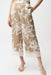 Woman wearing Joseph Ribkoff beige vanilla satin floral culotte pants with lace hem