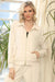Woman wearing a cream-colored zip up front jacket with pockets and long sleeves from Joseph Ribkoff
