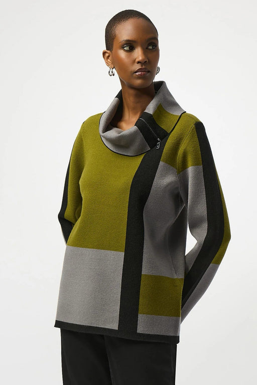 Woman wearing a green black and gray color block patterned sweater top with cowl neckline