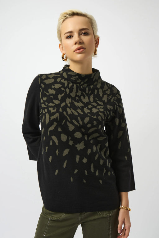 Woman wearing a black sweater top with green animal pattern and mock neckline