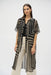 Woman wearing a long, geometric patterned sheer, chiffon blouse