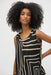 Woman wearing a Joseph Ribkoff silky knit geometric print sleeveless top with a scoop neckline and high-low hem, styled for office wear, travel, or casual daytime outings.