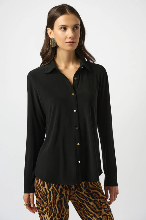 Woman wearing a black silky knit shirt with button front and long sleeves