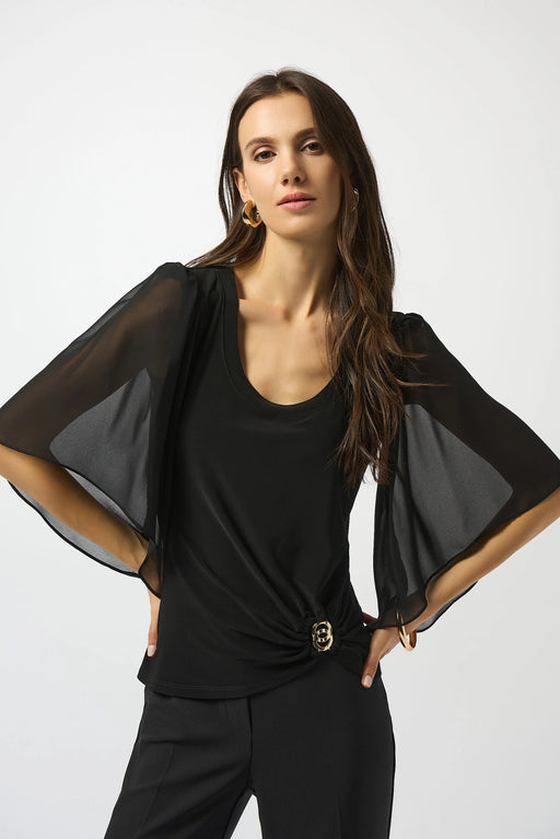 Woman wearing a black fitted top with scoop neck and chiffon sleeves