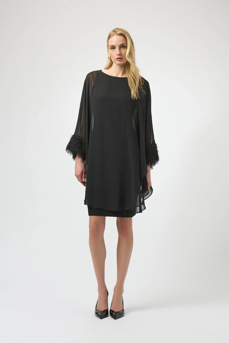 Woman wearing a black dress with chiffon overlay and fringe cuff detail from Joseph Ribkoff