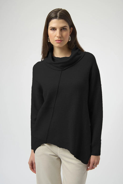 Woman wearing a solid color black sweater knit top with cowl neck and asymmetric hem