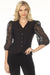 Woman wearing a black fitted blazer jacket with button front and embroidered puff sleeves from Joseph Ribkoff