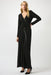 Woman wearing a black wide leg jumpsuit with wrap front look and leatherette trim from Joseph Ribkoff